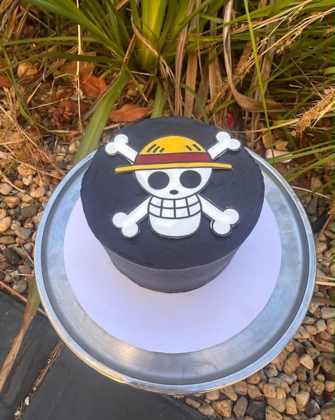 Black One Piece birthday cake with Luffy Straw Hat Pirates skull and crossbones edible print on top